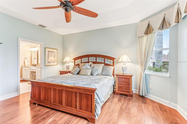 bedroom with light wood finished floors, visible vents, a ceiling fan, ensuite bath, and baseboards