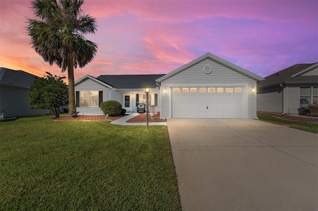 ranch-style house featuring a yard and a garage