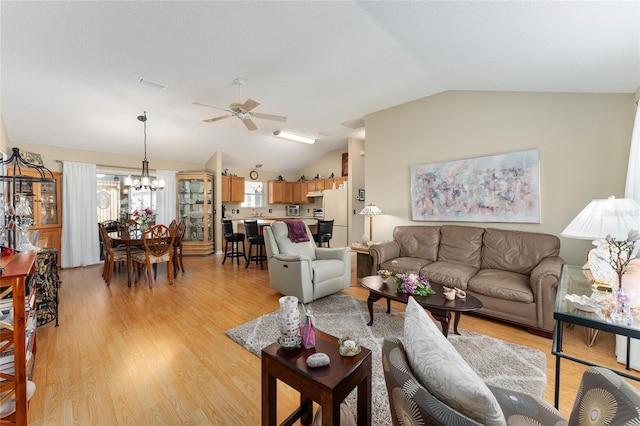 living room with light hardwood / wood-style floors, lofted ceiling, and ceiling fan with notable chandelier