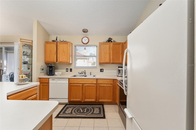 kitchen with light tile patterned floors, a textured ceiling, vaulted ceiling, sink, and white appliances