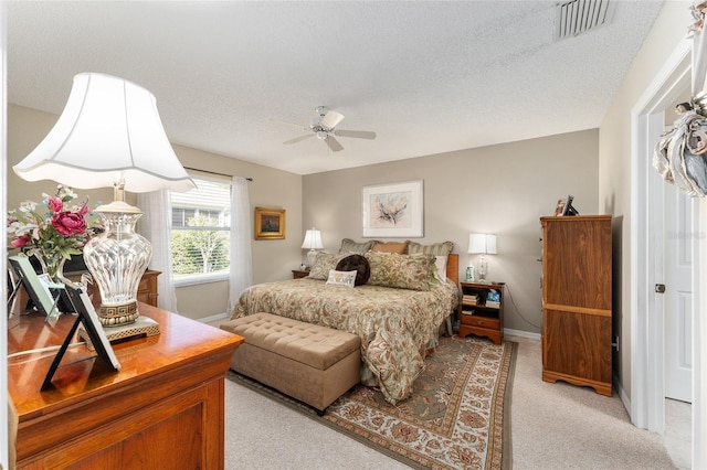 carpeted bedroom featuring a textured ceiling and ceiling fan