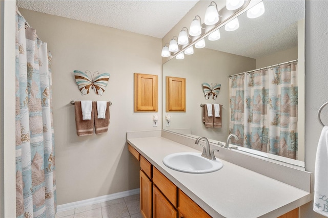 bathroom with vanity, a textured ceiling, and tile patterned floors