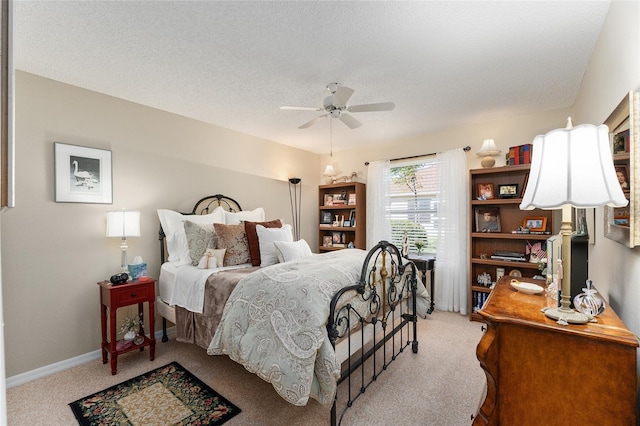 carpeted bedroom with a textured ceiling and ceiling fan