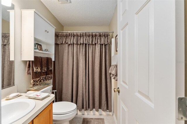 1312 Landeros Ln, The Villages, FL 32159 - full bath with vanity, tile patterned flooring, toilet, a textured ceiling, and a shower with curtain