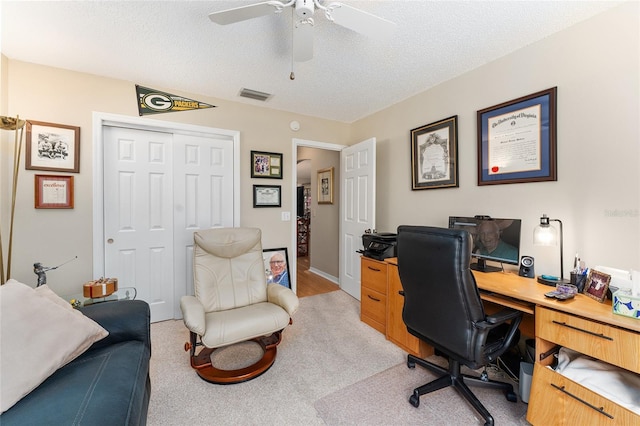 home office with light carpet, a textured ceiling, and ceiling fan