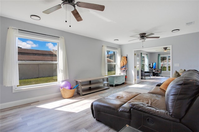 living room with ceiling fan, a healthy amount of sunlight, and light hardwood / wood-style flooring