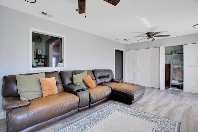 living room featuring light wood-type flooring and ceiling fan