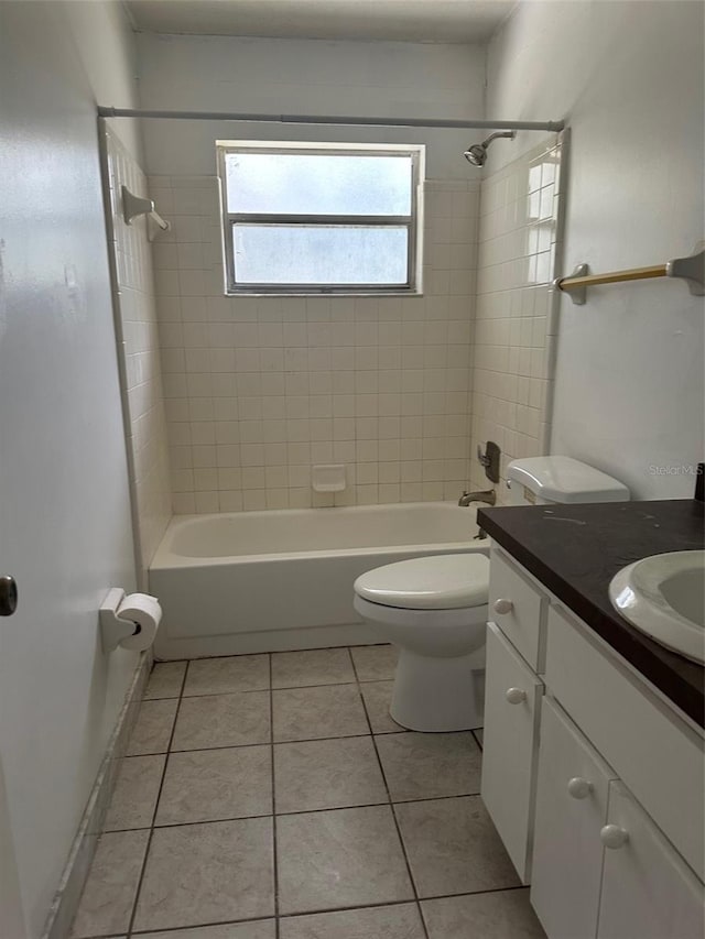 full bathroom featuring vanity, toilet, tile patterned floors, and tiled shower / bath