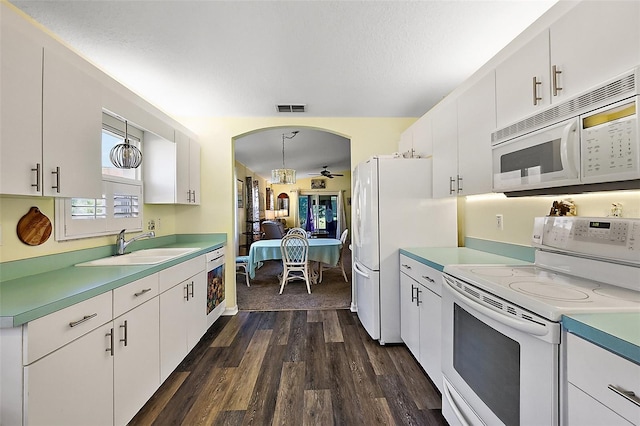 kitchen featuring white cabinets, pendant lighting, and white appliances