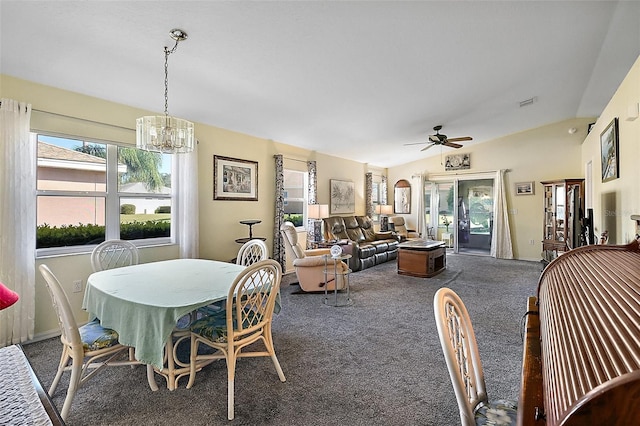 carpeted dining area with vaulted ceiling and ceiling fan with notable chandelier