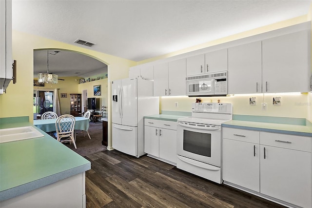 kitchen with dark hardwood / wood-style flooring, white cabinetry, pendant lighting, and white appliances