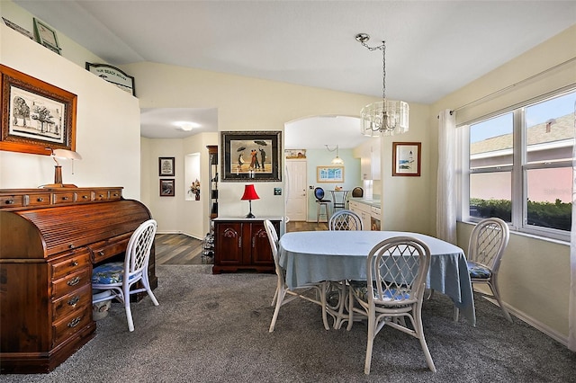 dining room featuring lofted ceiling, a chandelier, and dark hardwood / wood-style flooring