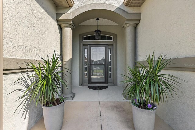 doorway to property featuring stucco siding