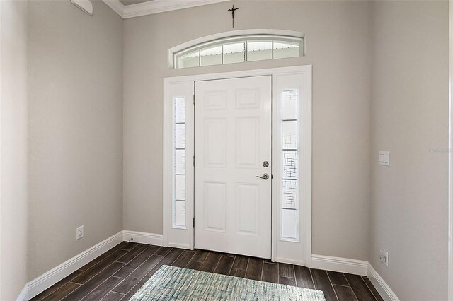entrance foyer with baseboards, ornamental molding, plenty of natural light, and wood finish floors