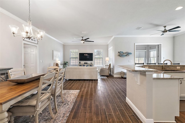 kitchen with dark hardwood / wood-style floors, sink, light stone counters, and pendant lighting