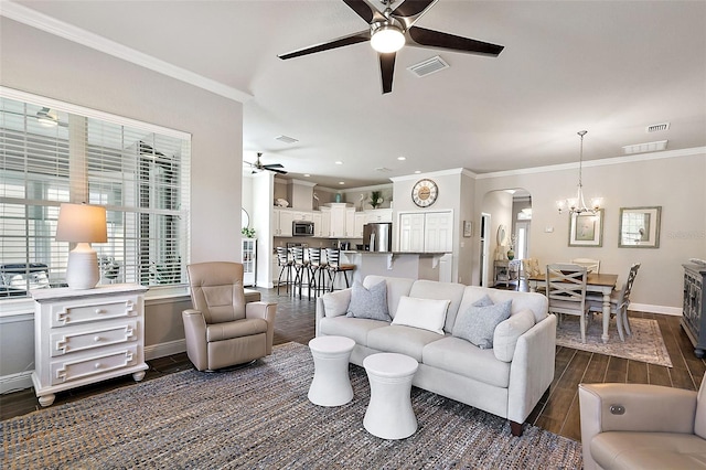 living room with crown molding, dark hardwood / wood-style floors, and ceiling fan with notable chandelier