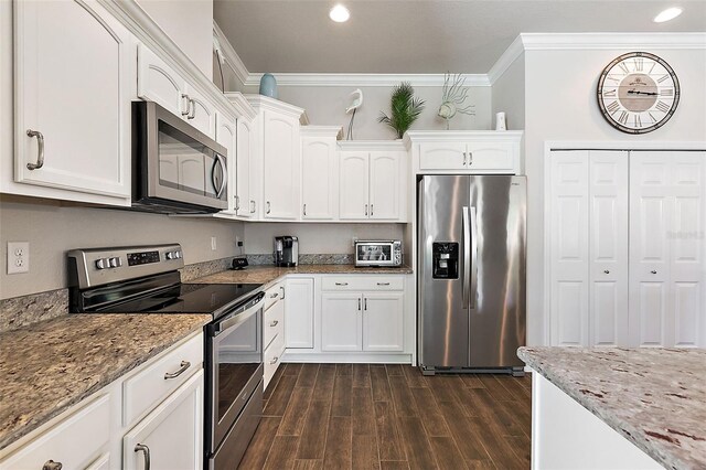 kitchen with light stone countertops, ornamental molding, stainless steel appliances, white cabinetry, and dark wood-type flooring