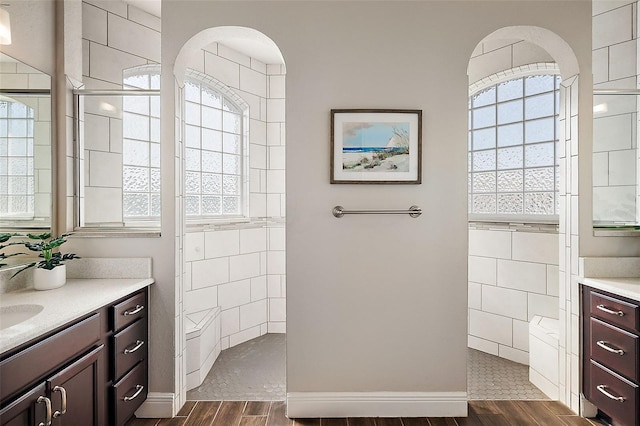 full bathroom featuring vanity, walk in shower, wood finished floors, and tile walls