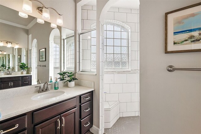 full bathroom featuring a sink, crown molding, walk in shower, and a healthy amount of sunlight