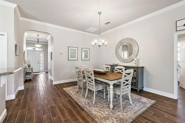 dining area with crown molding, visible vents, baseboards, dark wood-type flooring, and arched walkways