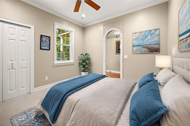 bedroom with light carpet, crown molding, a closet, and ceiling fan