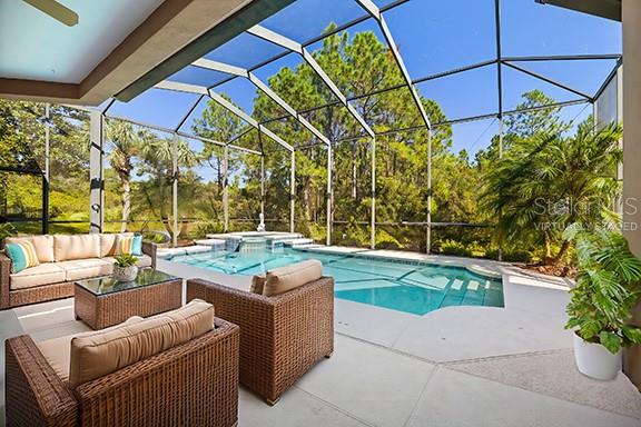 view of pool featuring an in ground hot tub, a lanai, an outdoor hangout area, and a patio