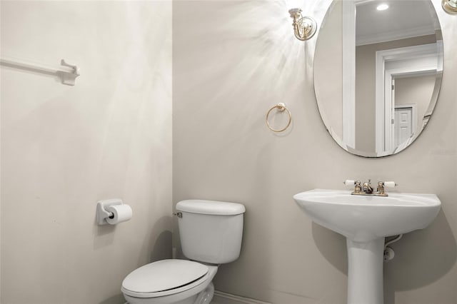 bathroom with ornamental molding and toilet