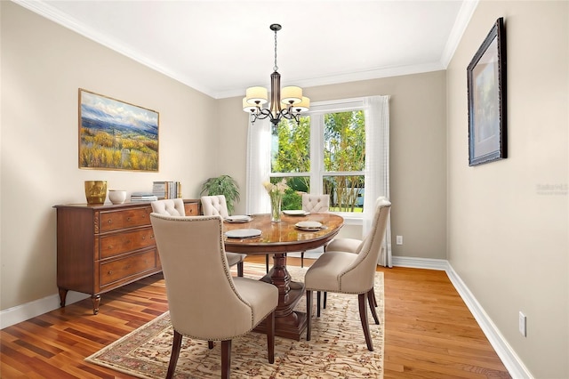 dining area featuring an inviting chandelier, ornamental molding, and hardwood / wood-style floors