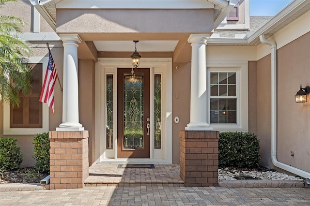 doorway to property featuring stucco siding and a porch