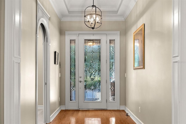 foyer featuring a chandelier, baseboards, light wood finished floors, and ornamental molding