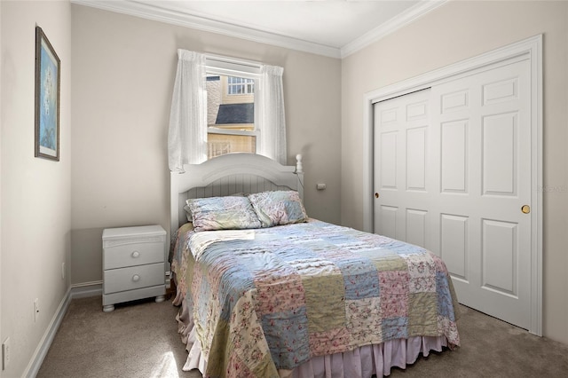 carpeted bedroom featuring a closet, baseboards, and ornamental molding