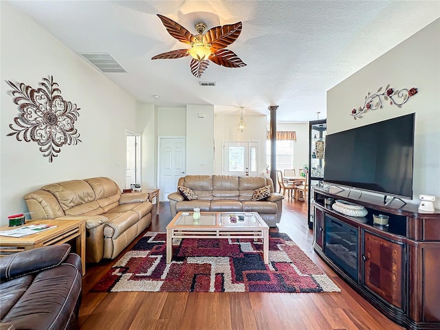 living room featuring a textured ceiling, hardwood / wood-style flooring, and ceiling fan