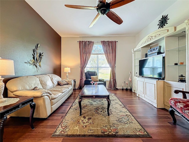 living room with dark wood-type flooring and ceiling fan