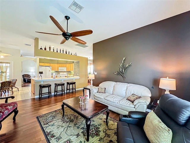 living room with ceiling fan and light hardwood / wood-style flooring