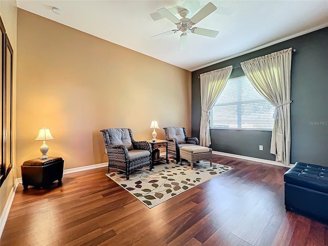 sitting room with dark wood-type flooring and ceiling fan