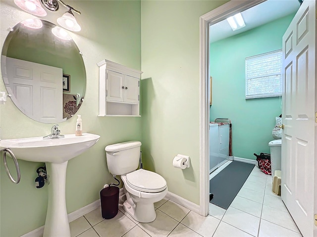 bathroom with toilet, a skylight, and tile patterned floors