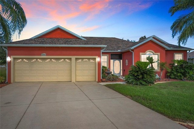 single story home with a garage and a lawn