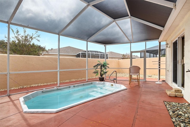 view of swimming pool with a hot tub, a patio area, and glass enclosure