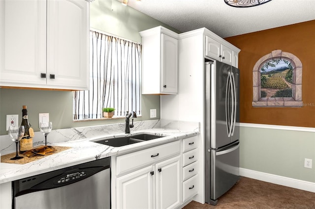 kitchen with stainless steel appliances, sink, light stone countertops, white cabinets, and a textured ceiling