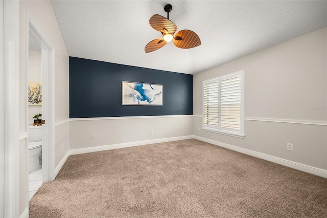 empty room featuring a textured ceiling, light colored carpet, and ceiling fan