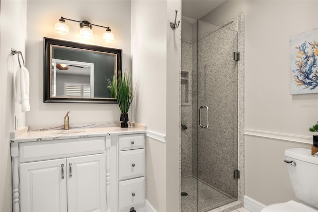 bathroom with a shower with door, toilet, and vanity