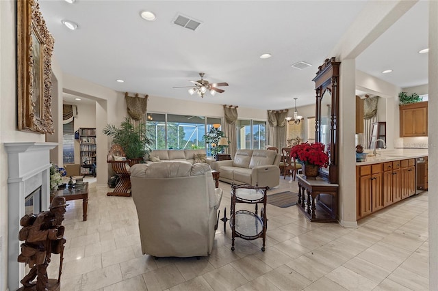 living room featuring ceiling fan with notable chandelier and sink