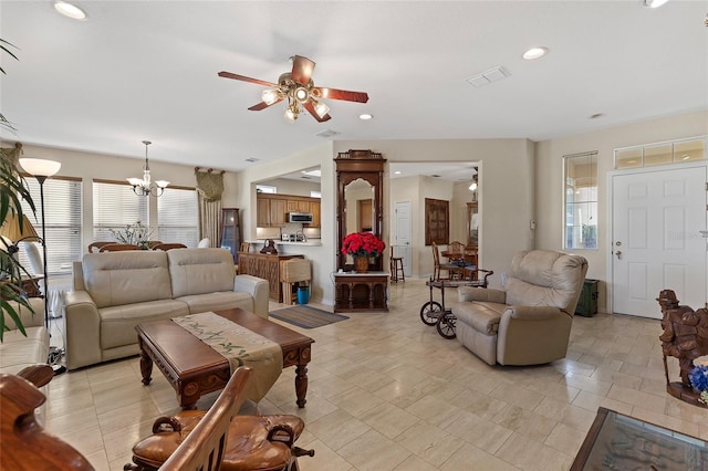 living room featuring plenty of natural light and ceiling fan with notable chandelier