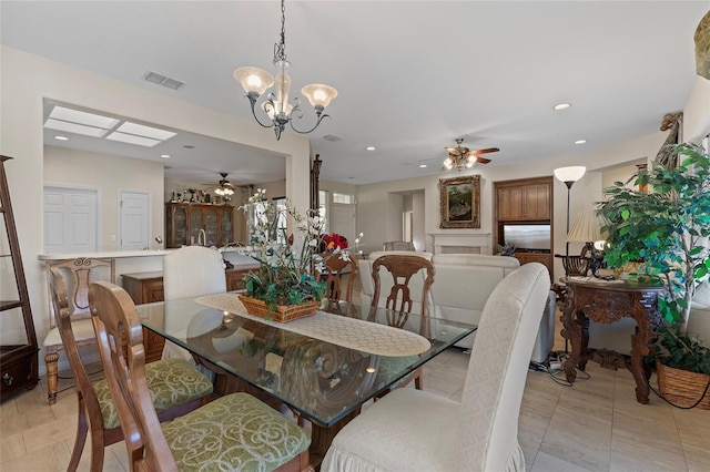 dining area featuring ceiling fan with notable chandelier