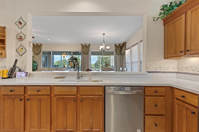 kitchen featuring dishwasher, sink, decorative backsplash, decorative light fixtures, and a chandelier