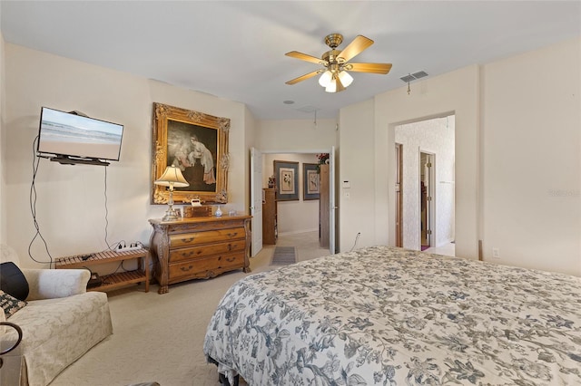 carpeted bedroom featuring ceiling fan and ensuite bath