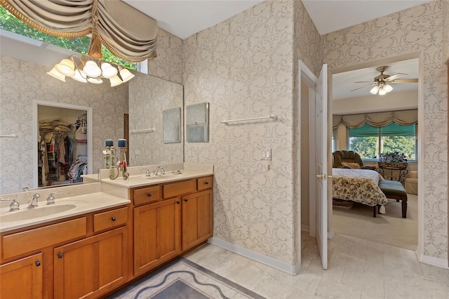 bathroom featuring ceiling fan with notable chandelier and vanity