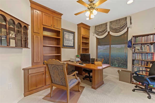 carpeted office space featuring ceiling fan