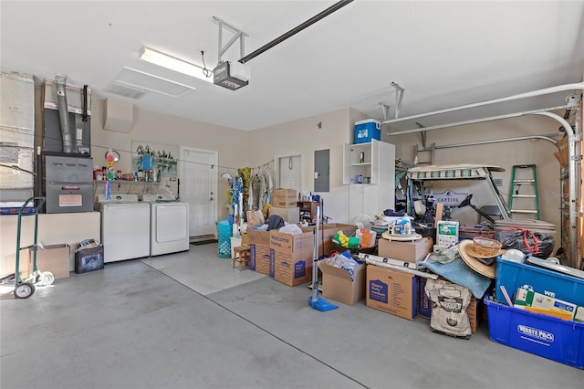 garage featuring electric panel, washer and dryer, and a garage door opener