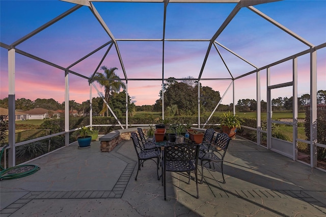 patio terrace at dusk featuring a lanai